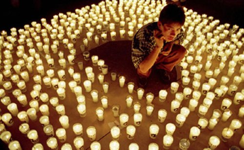A-Guatemalan-youth-stands-among-candles-set-up-to-form-the-words-Enough-Already_cropped
